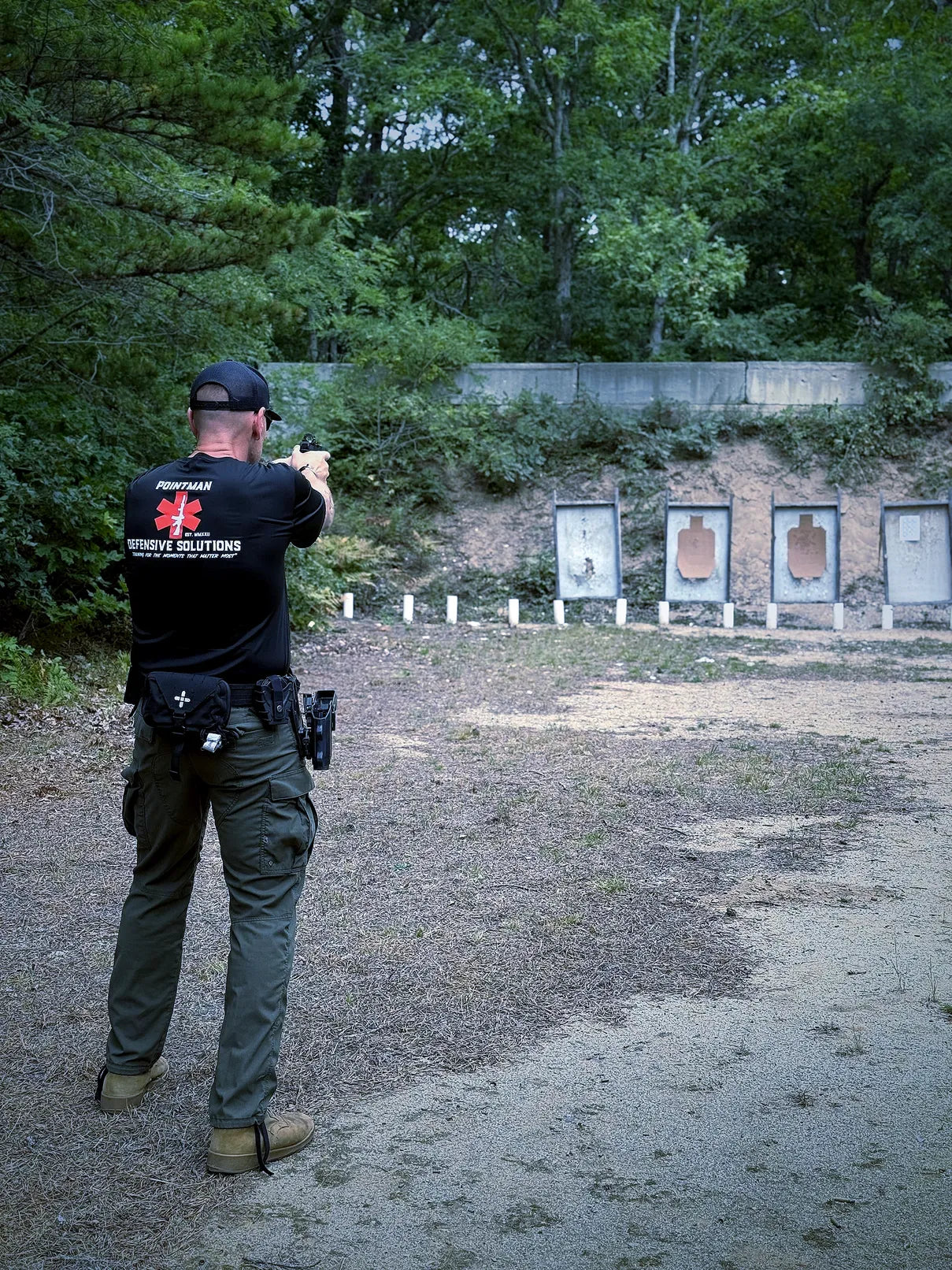 Pointman instructor demonstrating pistol skills on an outdoor range